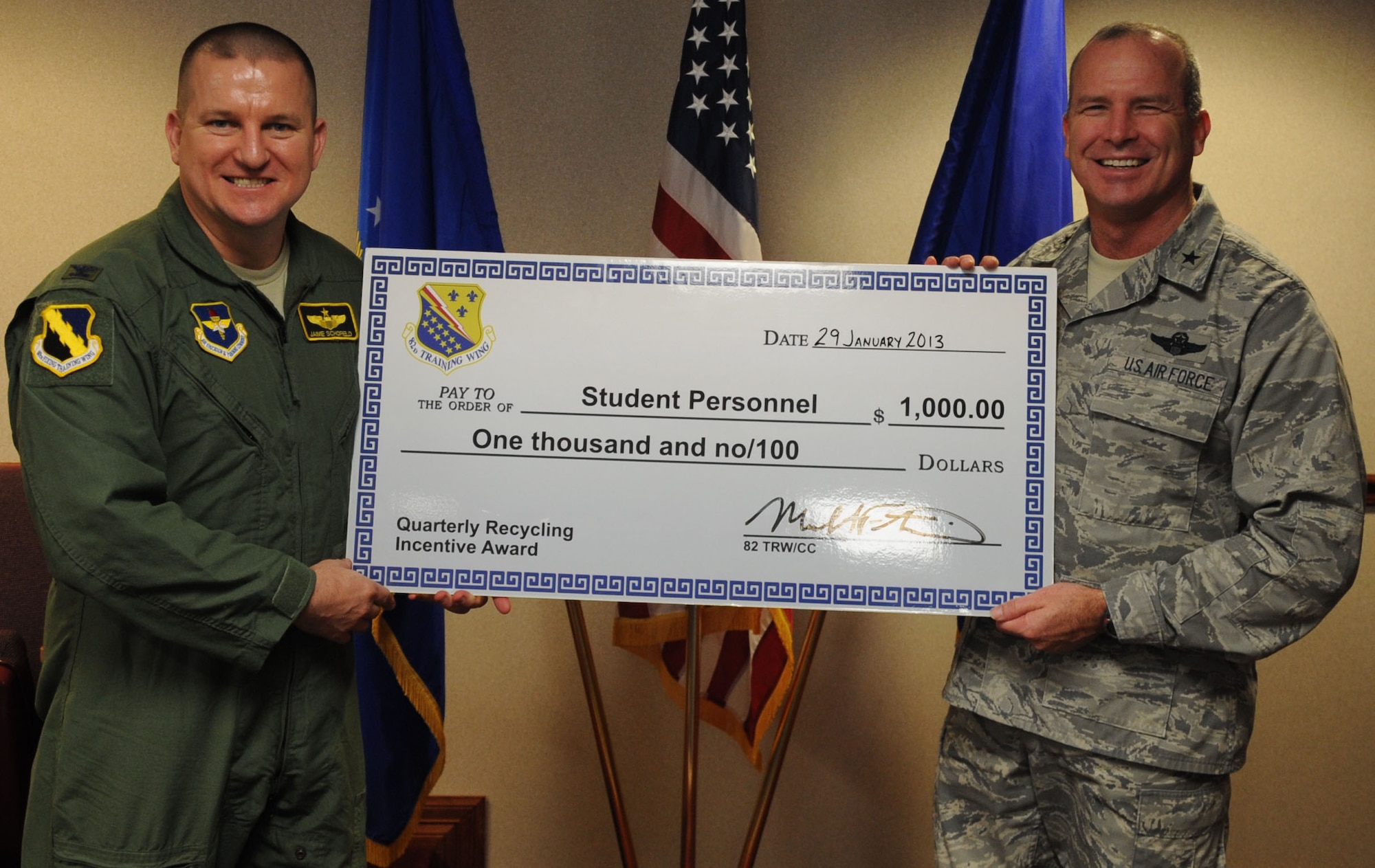 Brig. Gen. Michael Fantini (right), 82nd Training Wing commander, congratulates 80th Flying Training Wing vice-commander Col. Jaime Schofield after the wing was named as the student award winners for the FY13, 1st Quarter Recycling Awards.  The 80th FTW collected 10,374 pounds of recyclables this quarter. (U.S. Air Force photo/Airman 1st Class Jelani Gibson)