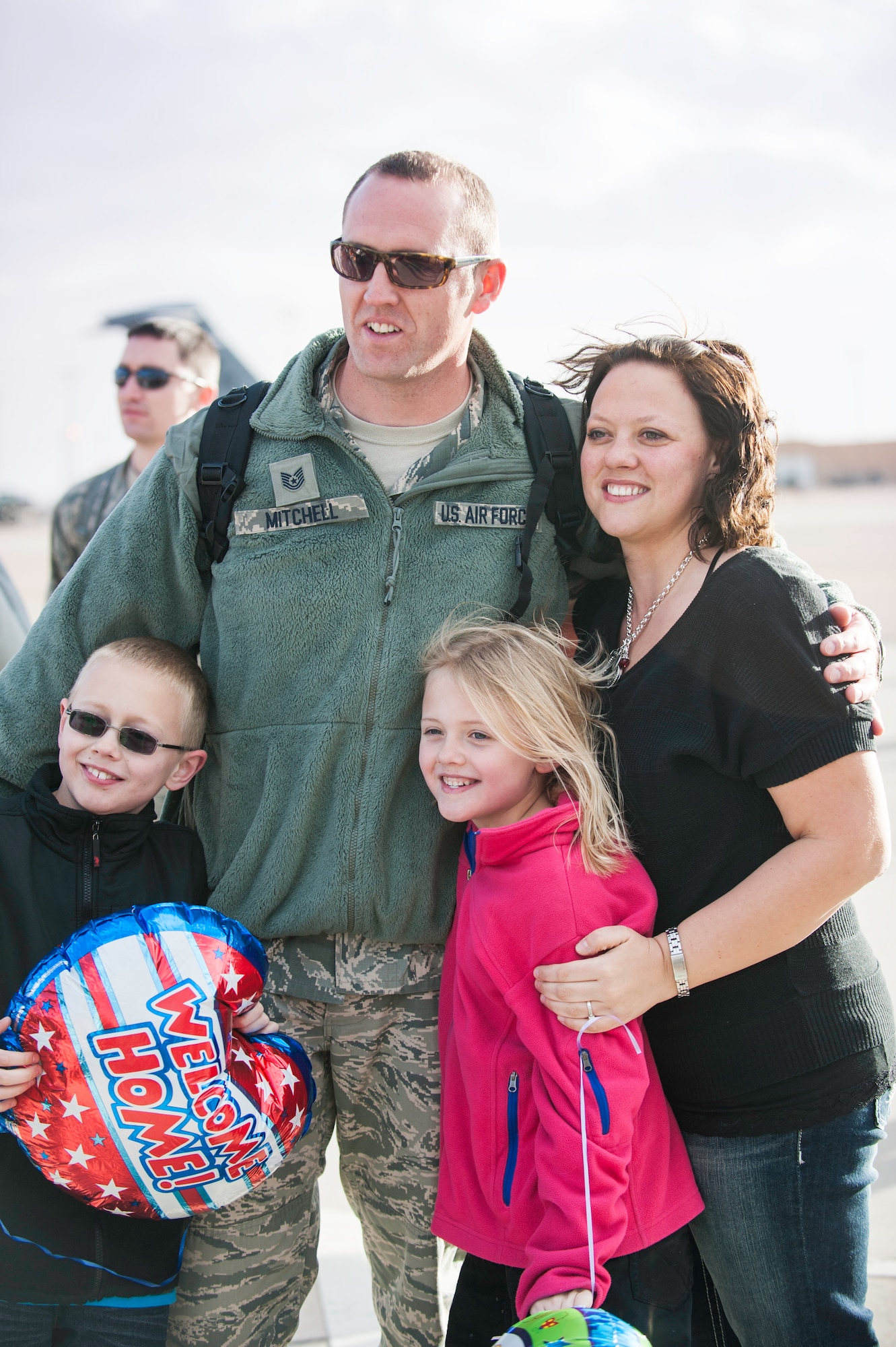 Technical Sgt. Stewart Mitchell, 49th Maintenance Squadron, greets his family after landing on the Holloman AFB, N.M., flightline Jan. 28.  F-22 Raptors and around 200 personnel returned Monday from a 9-month deployment to Southwest Asia ensuring regional security and joint tactical air operations.  (U.S. Air Force photo by 1st Lt. Stephanie Schonberger/Released)