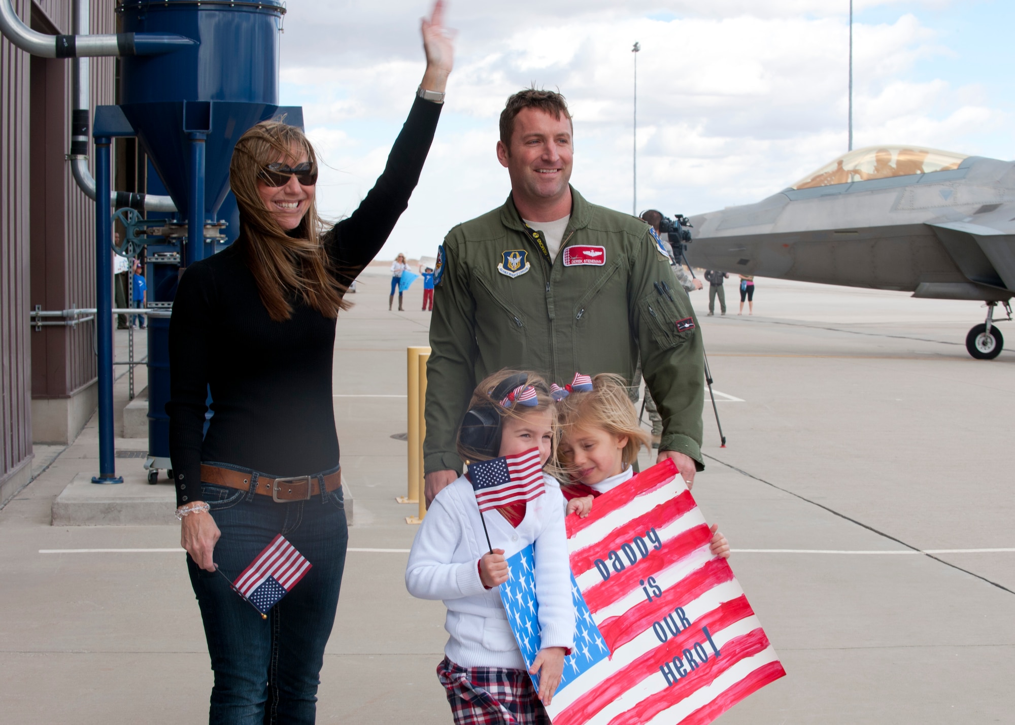 Friends and family await the return of the 7th Fighter Squadron F-22 Raptors pilots with homemade signs and flags on the Holloman AFB, N.M., flightline Jan. 28.  The F-22 Raptors and around 200 personnel returned Monday from a 9-month deployment to Southwest Asia ensuring regional security and joint tactical air operations. (U.S. Air Force photo by Airman 1st Class Leah Murray/Released)
	
