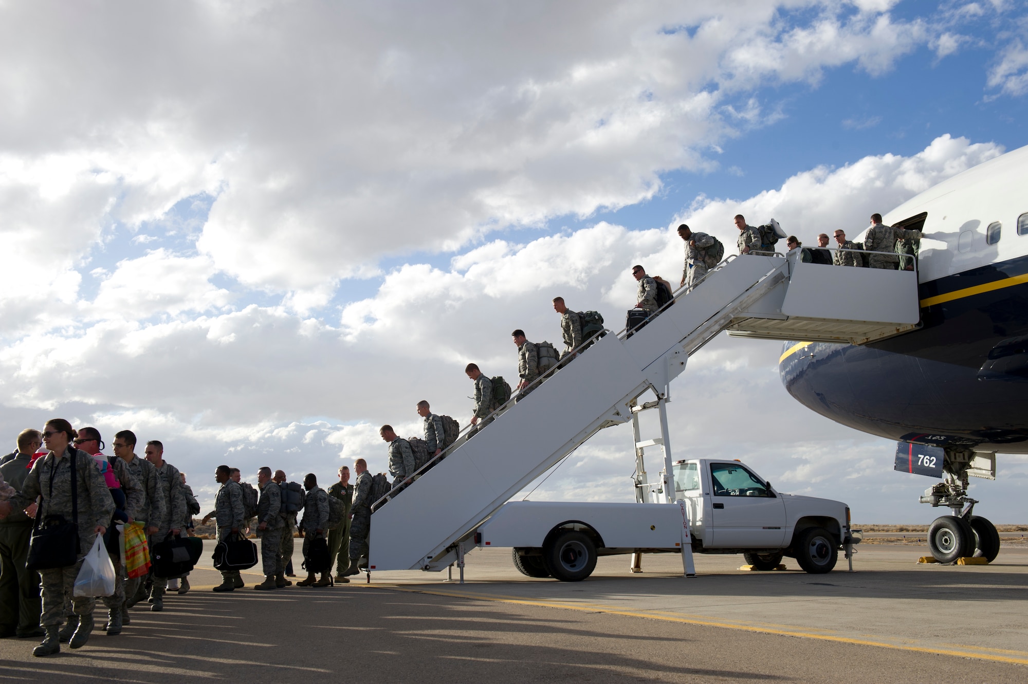 Airmen from the 7th Fighter Squadron and the 49th Maintenance Group deplane after landing at Holloman Air Force Base, N.M., Jan. 28. F-22 Raptors and around 200 personnel returned Monday from a 9-month deployment to Southwest Asia ensuring regional security and joint tactical air operations. (U.S. Air Force photo by Airman 1st Class Michael Shoemaker/Released)