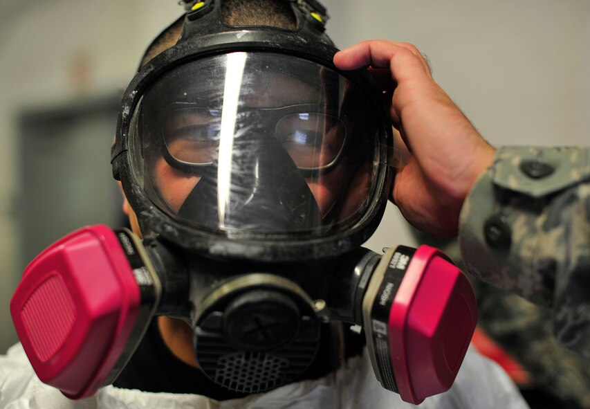 Tech. Sgt. John Mills-Hearne, a painter with the 459th Reserve Air Refueling Wing, has his protective mask straps adjusted before being exposed to a chemically filled room Jan. 23, 2013 at Joint Base Andrews, Md. Bioenvironmental engineers are required to sample air on location to help monitor the amount of chemicals workers are exposed to. (U.S Air Force photo/ Airman 1st Class Erin O’Shea)