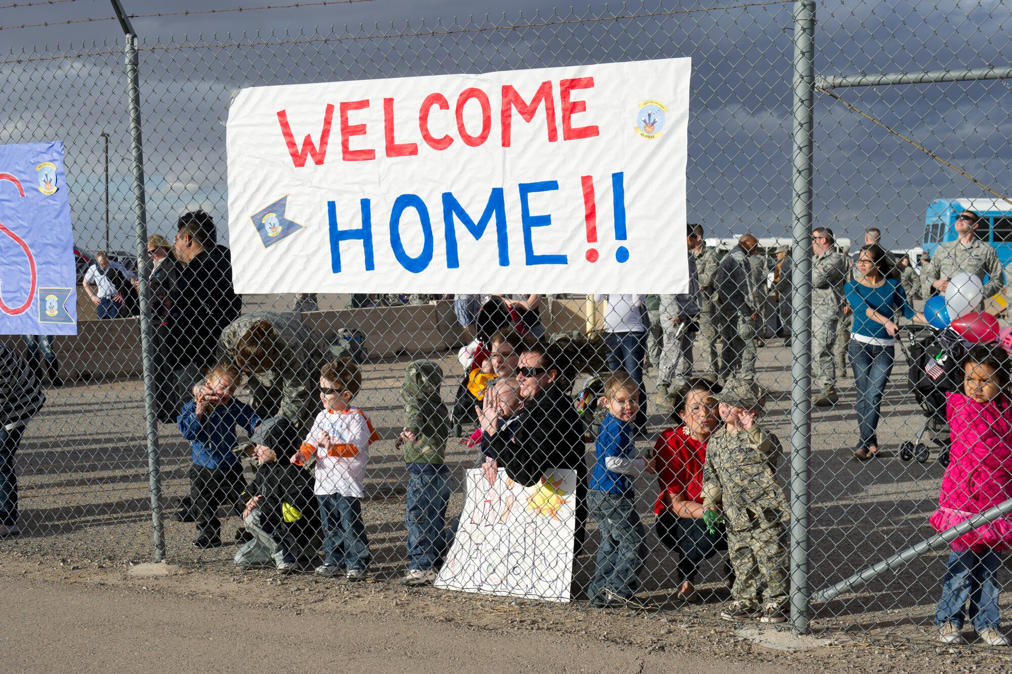 Friends and family await the return of around 200 Airmen from the 7th Fighter Squadron and the 49th Maintenance Group on the Holloman Air Force Base, N.M. flightline, Jan. 28. F-22 Raptors and around 200 personnel returned Monday from a 9-month deployment to Southwest Asia ensuring regional security and joint tactical air operations. (U.S. Air Force photo by Airman 1st Class Michael Shoemaker/Released)