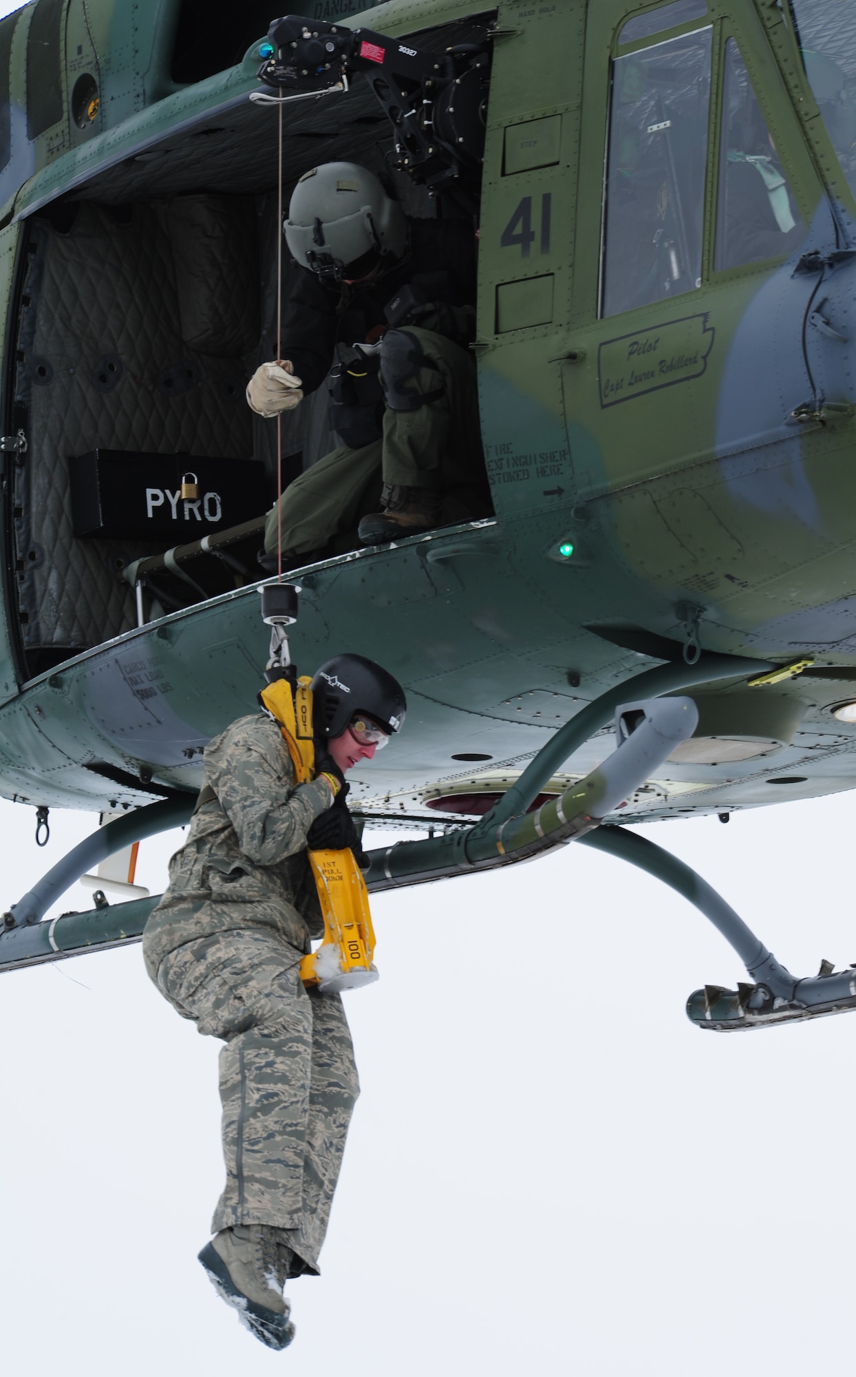 An SV80B student is lifted by a forest-penetrator hoist during a training exercise at the survival, evasion, resistance and escape school at Fairchild Air Force Base, Wash., Jan. 25, 2013. The SV80B course gives students an opportunity to experience firsthand how to safely be hoisted into a helicopter. (U.S. Air Force photo by Airman 1st Class Janelle Patiño)
