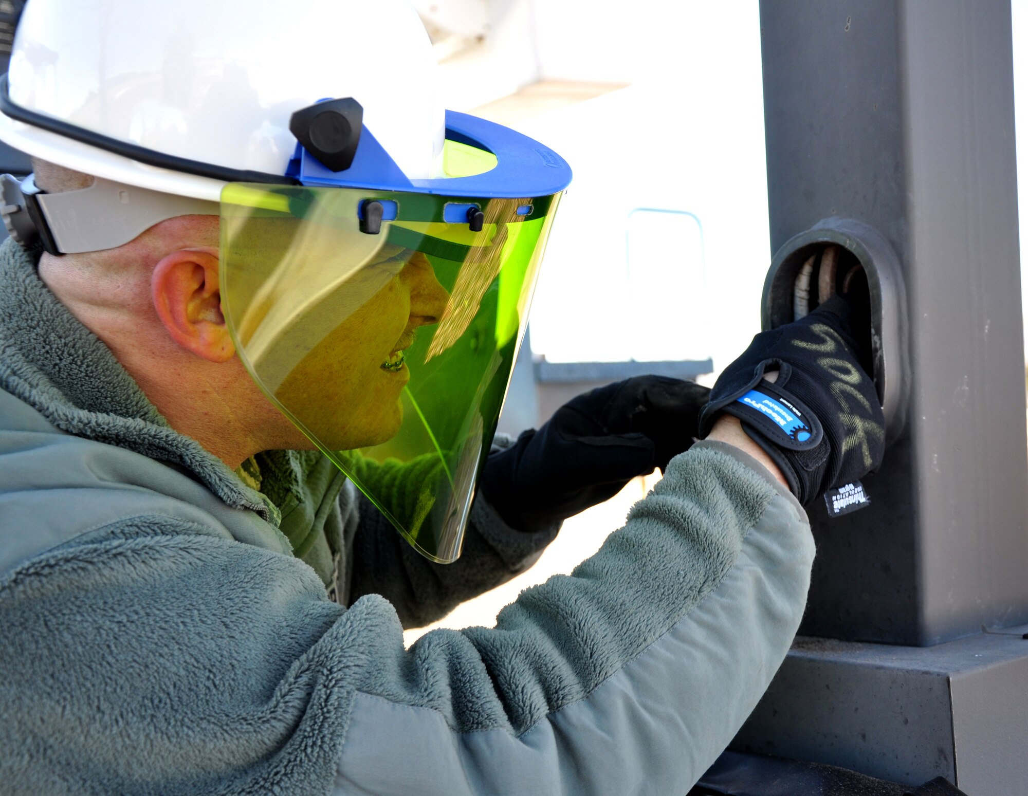 PETERSON AIR FORCE BASE, Colo. -- Staff Sgt. David Sockett, 21st Civil Engineer Squadron electrical systems craftsman, pulls wires out of a street lamp Jan. 4, 2012, at a parking lot east of the softball fields. The 21st CES operates and sustains essential facilities and utility infrastructure systems on base, responding to myriad work orders daily including maintaining roads, generators, and water and electrical lines. (U.S. Air Force photo/Senior Airman Jacob Morgan)
