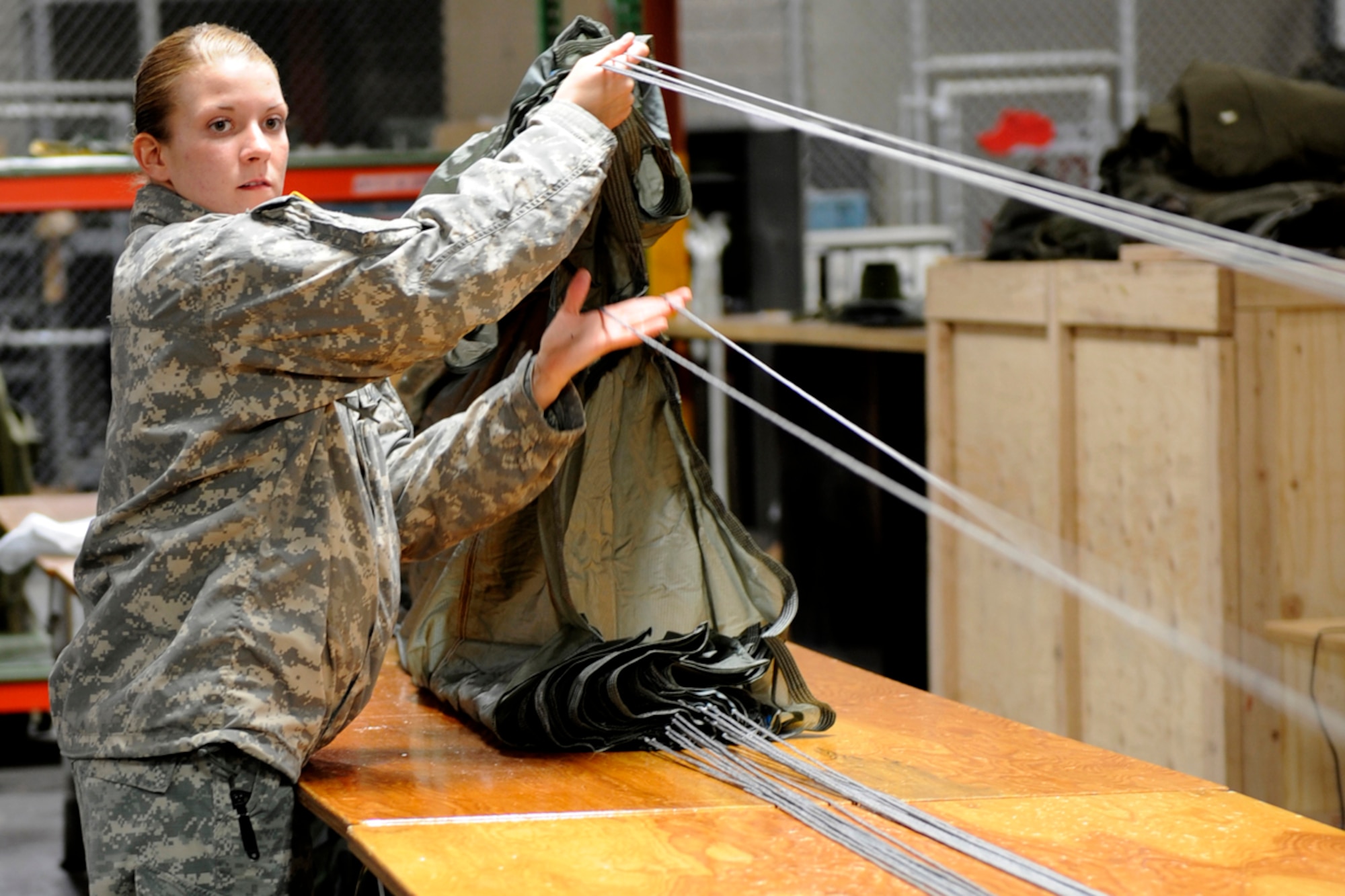 Parachute packer, Army Spc. Alex Harmon, from the 4th Quartermaster Detachment, separates each line attached to the parachute to ensure they are not tangled on JBER, Jan. 15. She is trained to ensure the parachutes are serviceable to soldiers fulfilling the Army?s mission. Harmon is from Merrill, Wis. 
