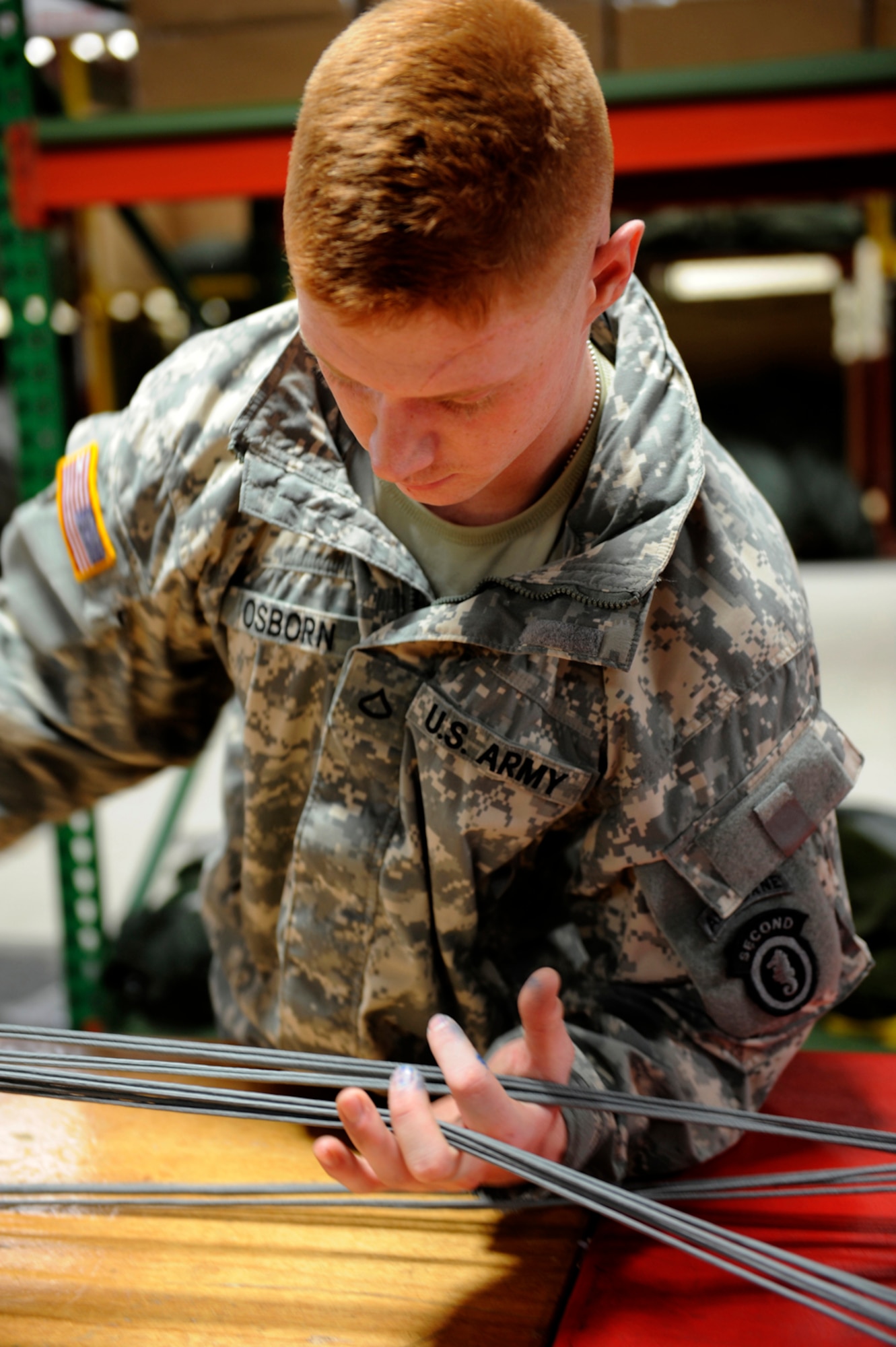 Parachute packer, Army Pfc. Christopher Osborne, from the 4th Quartermaster Detachment, separates each line attached to the parachute to ensure they are not tangled on JBER, Jan. 15. He is trained to ensure the parachutes are serviceable to soldiers fulfilling the Army?s mission. Harmon is from Atwater, Cali. 