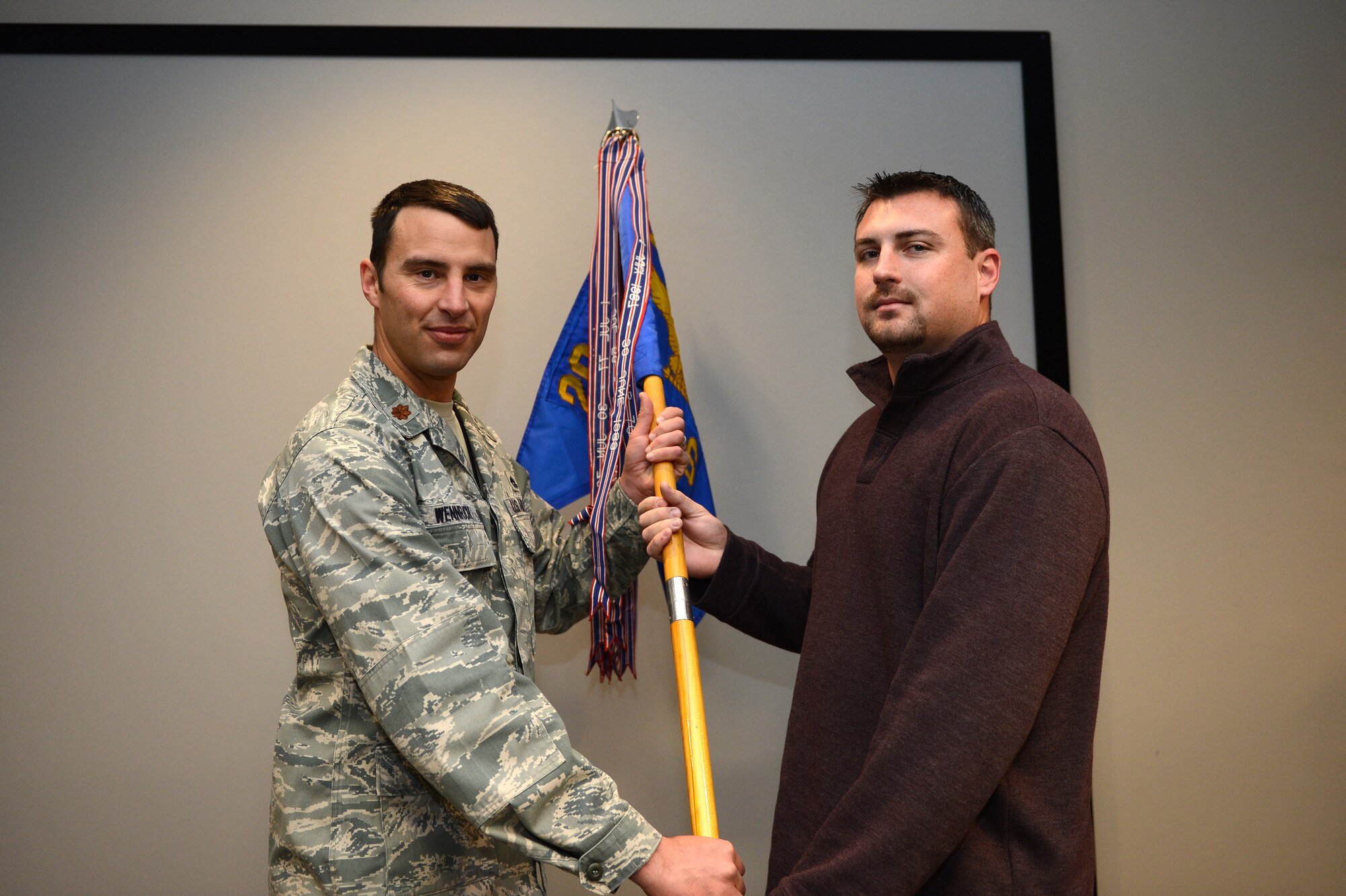 Maj. Joshua Wennrich, 20th Equipment Maintenance Squadron commander, hands the squadron guide-on to Rich Adams, Outback Steak House manager and new honorary commander at Shaw Air Force Base, S.C., Jan 25, 2013. The purpose of the Air Force honorary commander program is to increase public awareness and understanding of the armed forces and its mission, policies and programs of the AF, and to build relationships with members of the local community. (U.S. Air Force photo by Airman 1st Class Daniel Blackwell/Released)