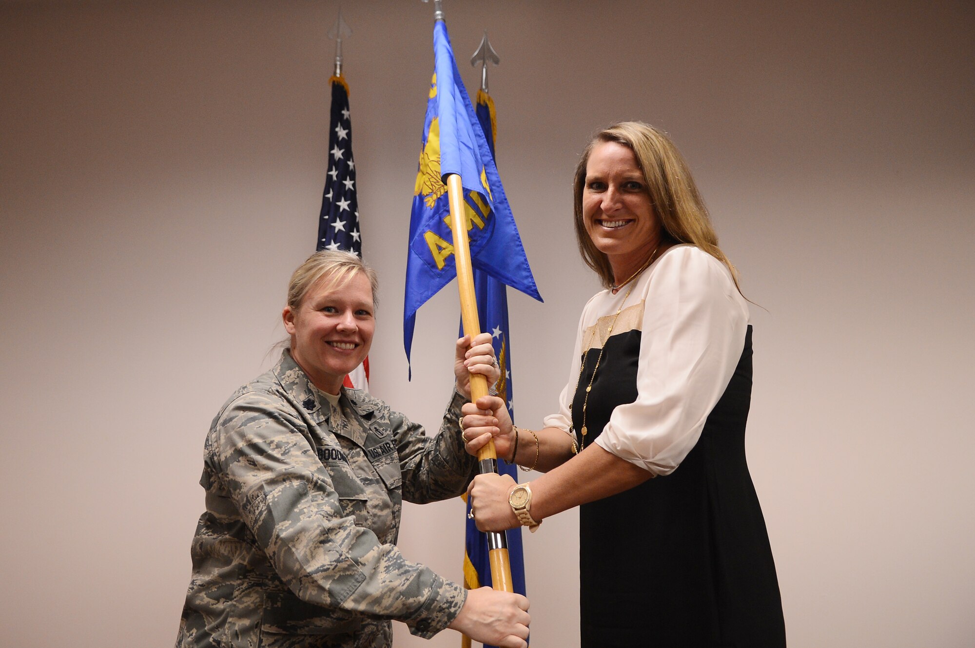 U.S. Air Force Lt. Col. Theresa Goodman , 20th  Aerospace Medical Squadron commander, presents Kimberley Cosineau  Sumter YMCA CEO, with a guide-on as she assumes the title of honorary commander for the 20th AMDS at Shaw Air Force Base, S.C., Jan. 22, 2013.  The purpose of the Air Force honorary commander program is to increase public awareness and understanding of the armed forces and its mission, policies and programs of the AF, and to build relationships with members of the local community and encourage them to share the AF story. (U.S. Air Force photo by Airman 1st Class Nicole Sikorski/Released)