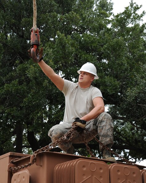 Staff Sgt. Shane Derrick, 2nd Civil Engineer Squadron electrical system craftsman, reaches for a crane hook that will be used to move a damaged transformer on Barksdale Air Force Base, La., Jan. 29. The damaged transformer was responsible for providing power to many base facilities to include the fire station and various hangers. (U.S. Air Force photo/Senior Airman Sean Martin)