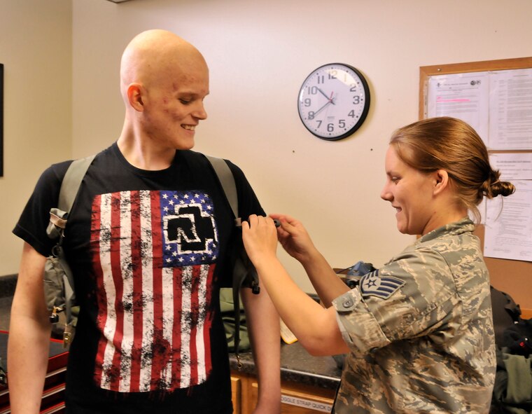 Staff Sgt. Sara Bolin adjusts a life preserver unit on Air Force Junior ROTC cadet Coleton Wells prior to his flight on a HH-60G Pave Hawk rescue helicopter. Wells spent the day touring the 920th Resue Wing and learning the ins and outs of rescue. Bolin is a aircrew equipment flight technician with the 920th RQW.  (U.S. Air Force photo/Tech. Sgt. Peter Dean) 
