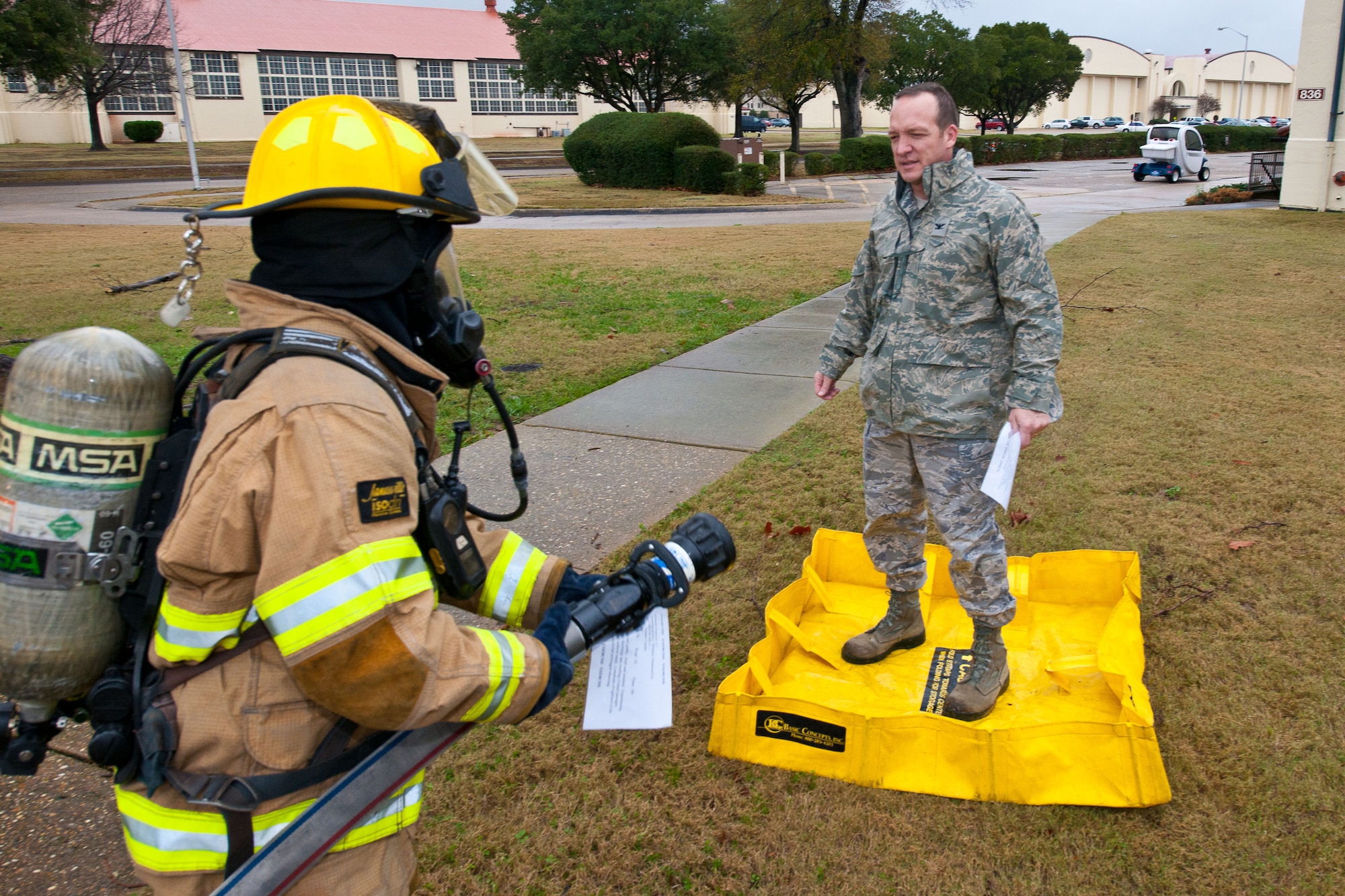 A member of the hazardous materials team simulates hosing down Col. Matthew Brand, Spaatz Academic Center's director, as part of the decontamination process on Maxwell Air Force Base during a nerve-agent exercise Jan 17. (U.S. Air Force photograph by Donna L. Burnett)