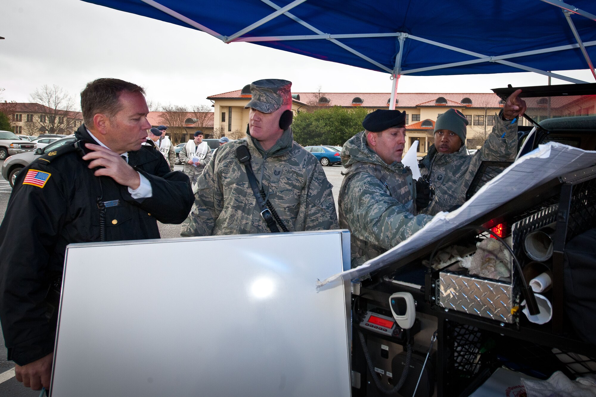 Deputy fire chief Charles Jorgensen, left, incident commander, discusses a cordon with security forces members outside building 836 on Maxwell Air Force Base during a nerve-agent exercise Jan 17. (U.S. Air Force photograph by Donna L. Burnett)