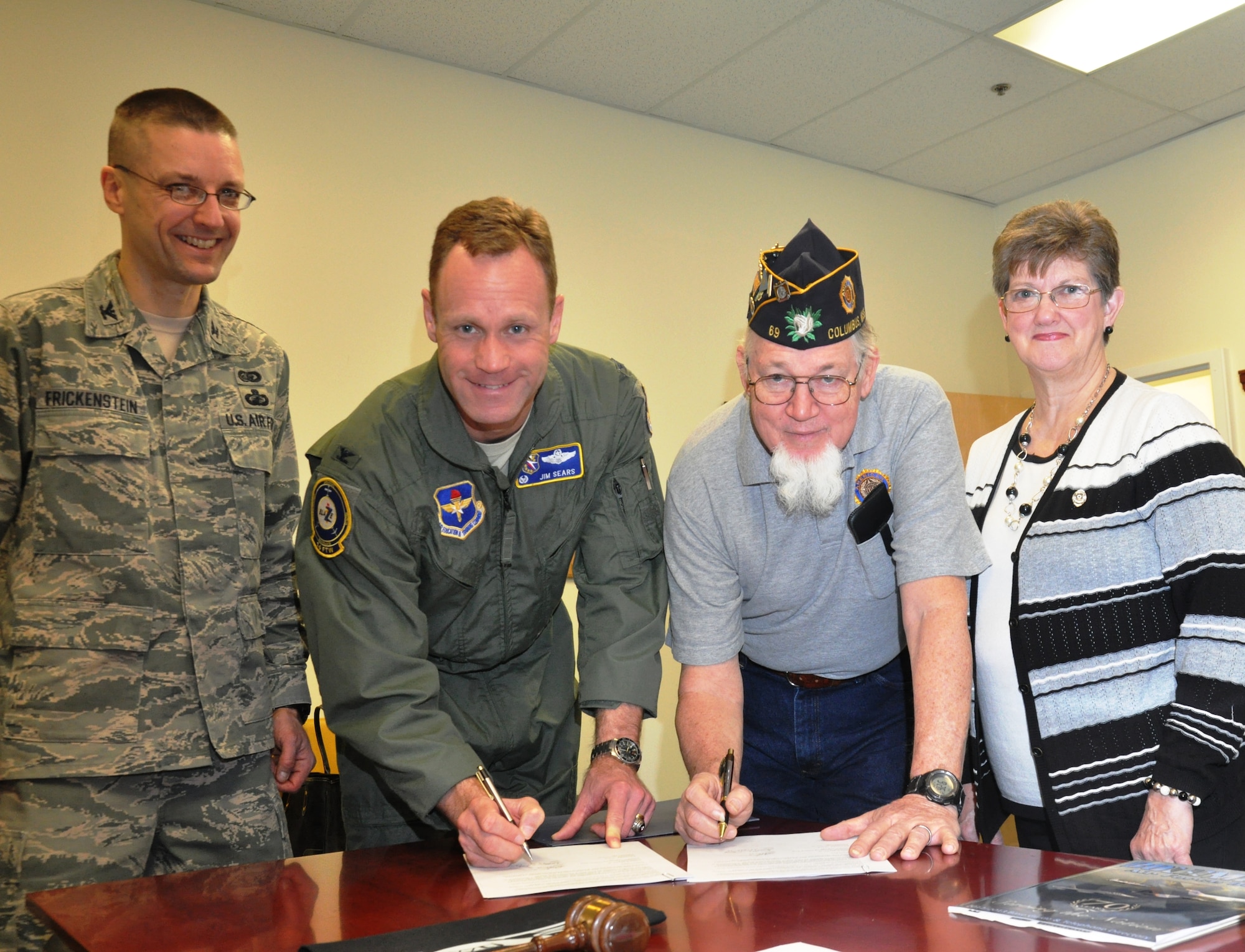 Col. Jim Sears, 14th Flying Training Wing commander and Bill Quick, American Legion Post 69 president, sign a Memorandum of Understanding that states Post 69 will host Columbus Air Force Base’s Emergency Family Assistance Center on Jan. 24 at the Post with Col. Scott Frickenstein, 14th Mission Support Group commander and Sarah Edwards, American Legion Ladies Auxiliary State President look-on. If the base cannot support the EFAC at the Columbus AFB Airman and Family Readiness Center, the American Legion will provide work center space.  The EFAC provides a one-stop shop for emergency assistance to Airmen and their families during crisis events. (U.S. Air Force Photo/Sonic Johnson)