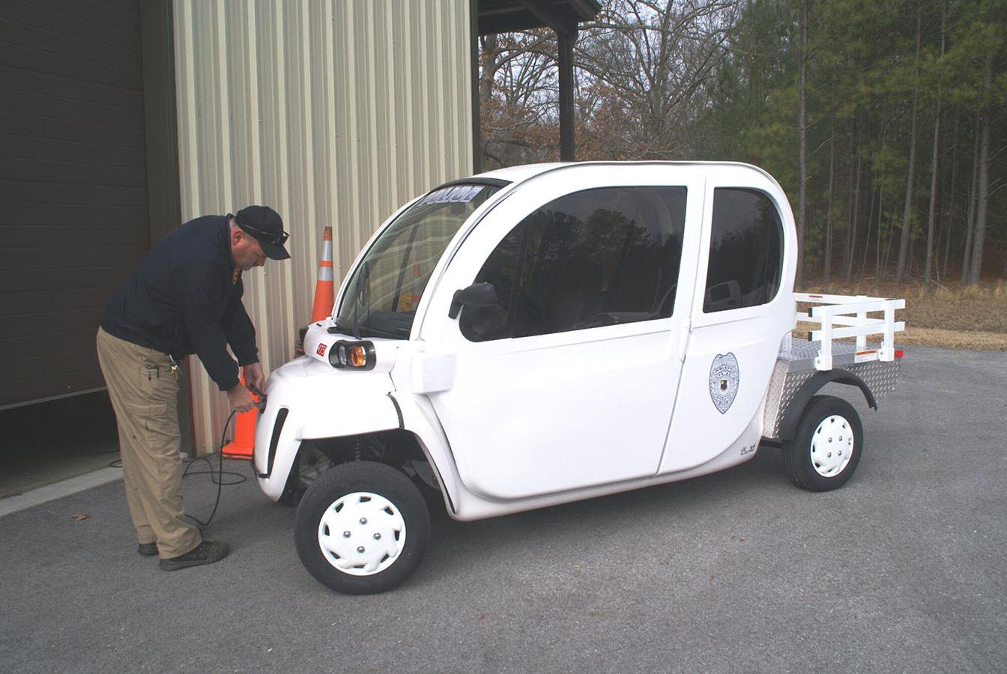 Buck Young, AEDC Police Department combat arms training manager, checks the electric connection for charging the battery of his department’s electric, low-speed Polaris GEM E-4 vehicle for use exclusively in the mission area of Arnold AFB. (Photo by Philip Lorenz III)