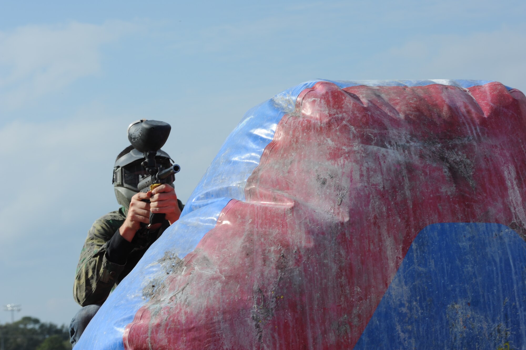 A Hurlburt Airman takes aim while behind an inflatable boundary during a paintball match at the base paintball field at Hurlburt Field, Fla., Jan. 25, 2013. The base community center provided the free rounds and use of equipment for Hurlburt Airmen. (U.S. Air Force photo / Senior Airman Joe McFadden)