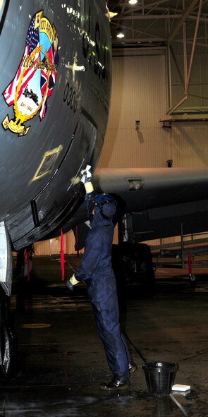 An Airman from the 100th Aircraft Maintenance Squadron washes a KC-135R Stratotanker during a full aircraft wash Jan. 25, 2013, in the washrack at RAF Mildenhall, England. A full wash takes approximately six hours, with a team of approximately six Airmen. Airmen wear  personal protective equipment while scrubbing the plane using aircraft soap, water, brushes and pads to give it a thorough wash, which helps prevent corrosion. Aircraft here are scheduled for a full clean every 90 days. (U.S. Air Force photo by Karen Abeyasekere/Released)