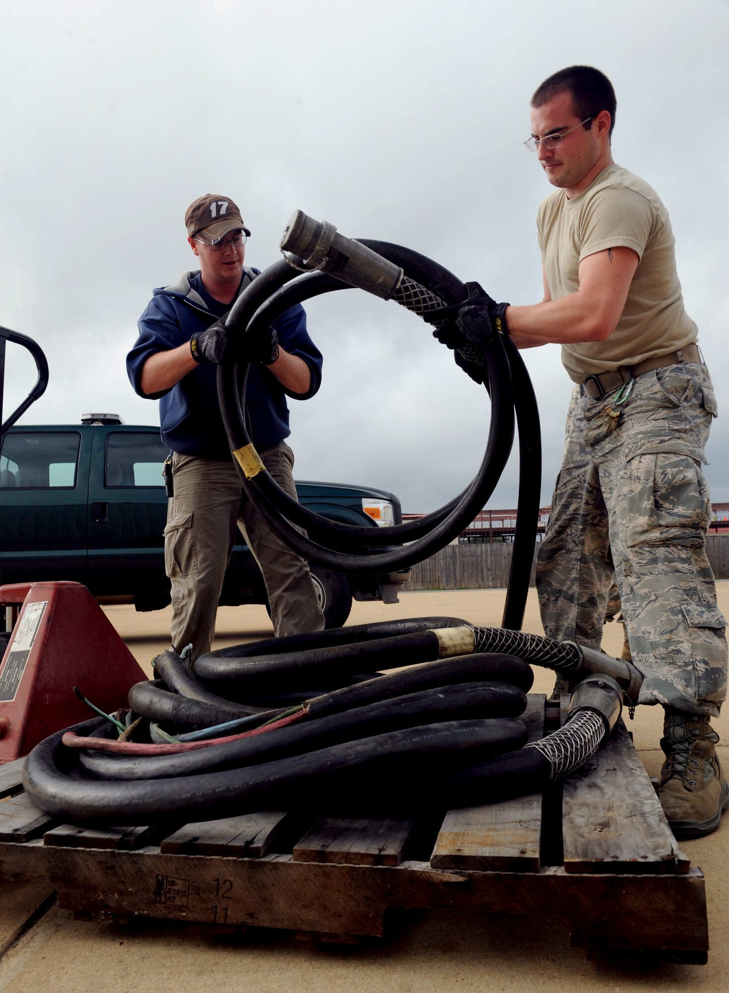 Stephen Mahannah and Senior Airman Steven Ainsworth, 2nd Civil Engineer Squadron electrical power production, place cables onto a pallet for transport on Barksdale Air Force Base, La., Jan. 28. Electrical power production Airmen maintain portable generators that give buildings power in the event of a power outage. (U.S. Air Force photo/Airman 1st Class Benjamin Gonsier)
