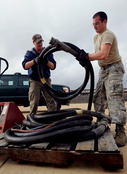 Stephen Mahannah and Senior Airman Steven Ainsworth, 2nd Civil Engineer Squadron electrical power production, place cables onto a pallet for transport on Barksdale Air Force Base, La., Jan. 28. Electrical power production Airmen maintain portable generators that give buildings power in the event of a power outage. (U.S. Air Force photo/Airman 1st Class Benjamin Gonsier)