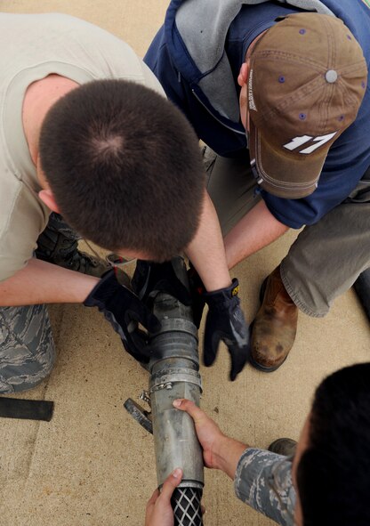 Technicians from the 2nd Civil Engineer Squadron electrical power production section disconnect a canon plug cable on Barksdale Air Force Base, La., Jan. 28. Electrical power production Airmen are responsible for maintaining the generators and electrical systems on base. Airmen must have knowledge of electronics and electrical systems to do most of their work. (U.S. Air Force photo/Airman 1st Class Benjamin Gonsier)