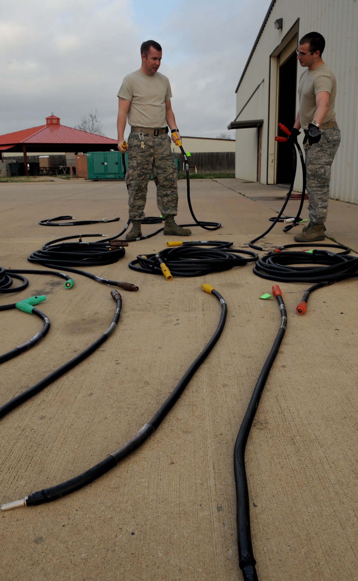 Staff Sgt. Marcial Grinolds and Senior Airman Steven Ainsworth, 2nd Civil Engineer Squadron electrical power production, organize camelot cables on Barksdale Air Force Base, La., Jan. 28. The camelot cables are color coded to help Airmen identify where in the generator each cable is connected to. (U.S. Air Force photo/Airman 1st Class Benjamin Gonsier)
