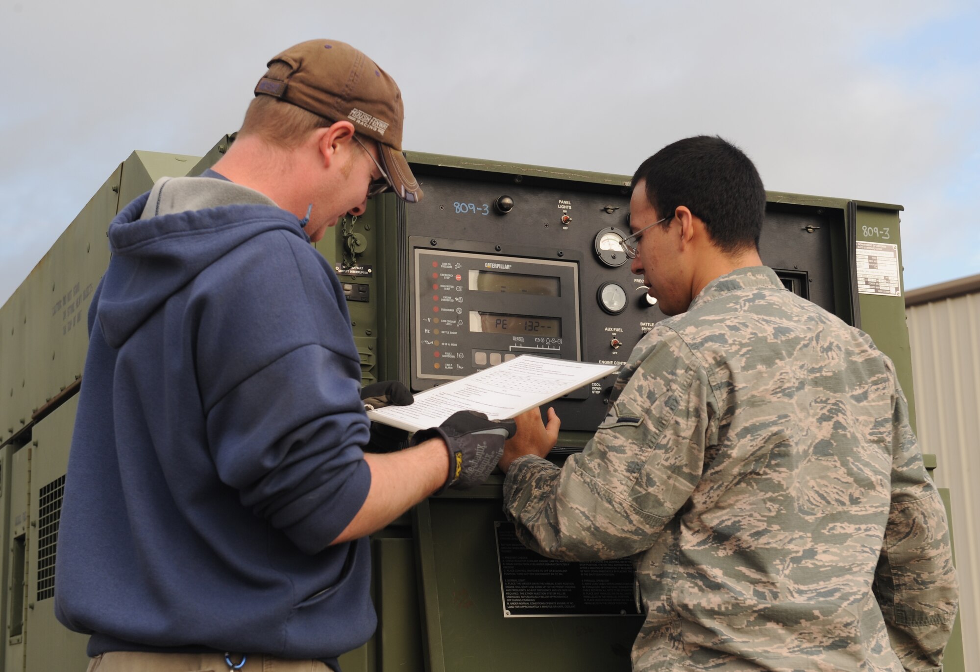 Stephen Mahannah and Airman Francisco Cerda, 2nd Civil Engineer Squadron electrical power production, configure an MEP-809 generator on Barksdale Air Force Base, La., Jan. 28. The generator is used for emergencies during a power outage. (U.S. Air Force photo/Airman 1st Class Benjamin Gonsier)
