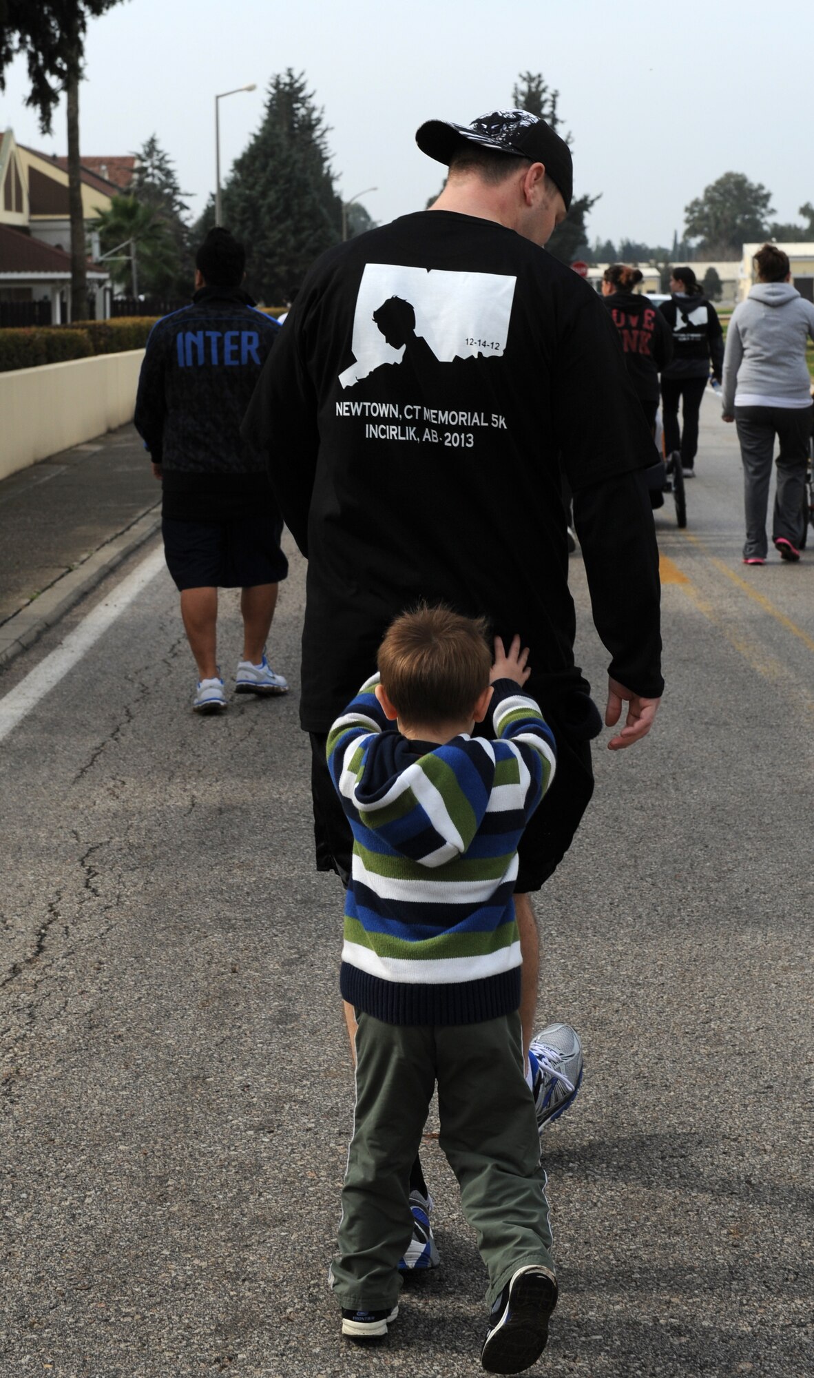 A child pushes his father to run during the Newtown, Conn., Memorial 5k Jan. 26, 2013, at Incirlik Air Base, Turkey. More than 100 people participated in the event to raise money for the United Way charity set up to help families affected by the Dec. 14 shooting at  Sandy Hook Elementary school which took the lives of 20 children and six adults. (U.S. Air Force photo by Staff Sgt. Marissa Tucker/Released) 

