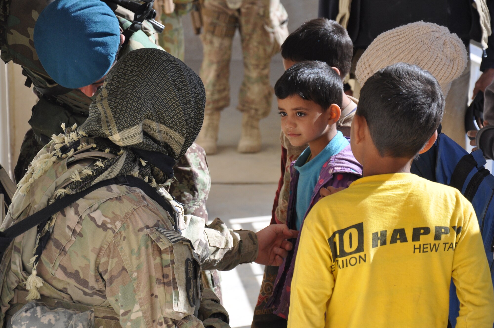 Airman 1st Class Jessica Humke, a security forces Airman with Flightline Security at Kandahar Airfield, talks to an Afghan boy at a school near KAF on Jan. 24. Afghan Air Force security forces airmen led a mission to deliver supplies to the school, which was carried out with logistical and security support from Coalition forces. (U.S. Air Force photo/Capt. Tristan Hinderliter)