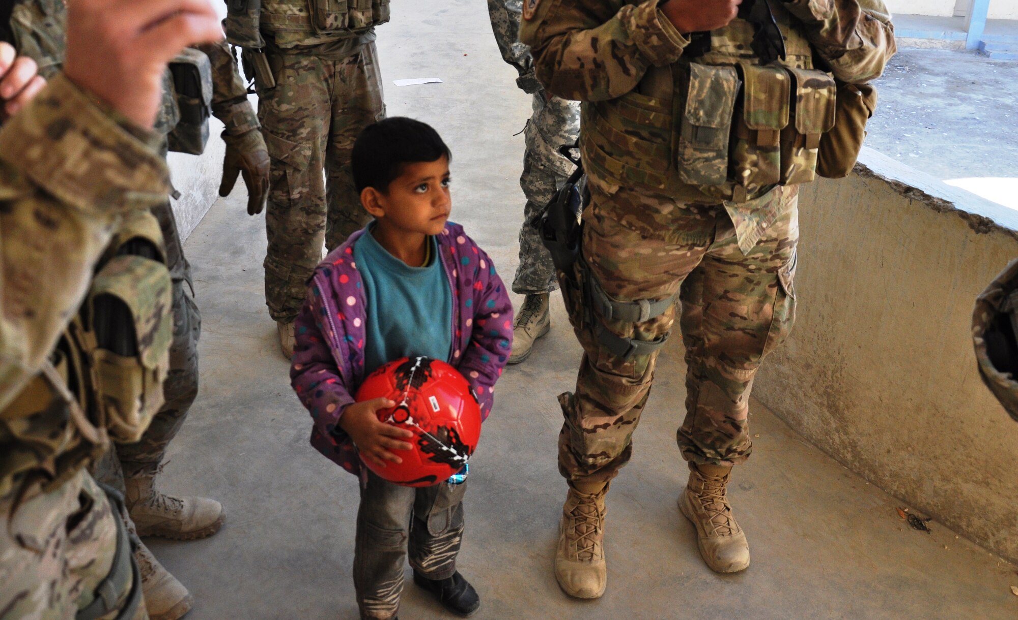 An Afghan student at a school near Kandahar Airfield holds a soccer ball he received from Afghan Air Force security forces airmen on Jan. 24. The mission to deliver supplies to the school was led by the Afghans and carried out with logistical and security support from Coalition forces. (U.S. Air Force photo/Capt. Tristan Hinderliter)