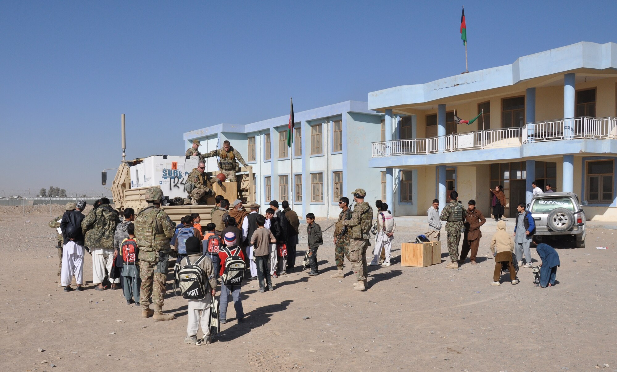 Afghan Air Force security forces airmen with the Kandahar Air Wing hand out school supplies at a school near Kandahar Airfield on Jan. 24. The mission was led by the Afghans and carried out with logistical and security support from Coalition forces. (U.S. Air Force photo/Capt. Tristan Hinderliter)