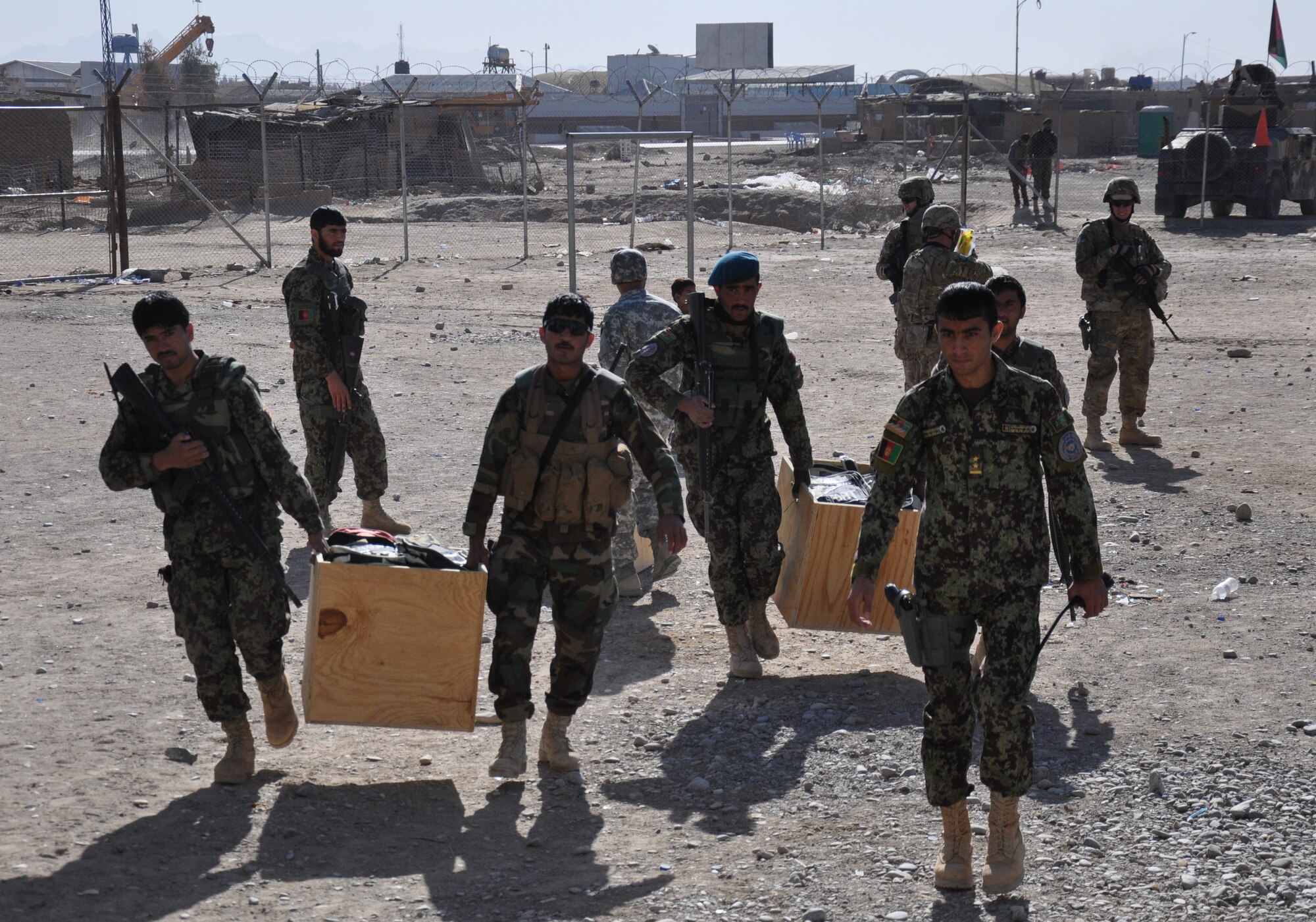 Afghan Air Force security forces airmen with the Kandahar Air Wing carry school supplies to a school near Kandahar Airfield on Jan. 24. The mission was led by the Afghans and carried out with logistical and security support from Coalition forces. (U.S. Air Force photo/Capt. Tristan Hinderliter)