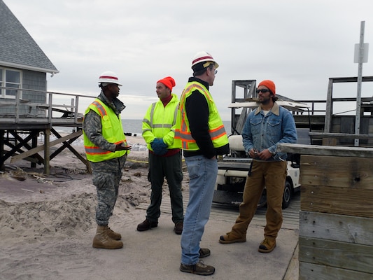 New York Recovery Field Office Commander Lt. Col. John A. Knight (at left) and RFO Operations Chief Sean O'Donnell speak with local homeowners, Fire Island, N.Y., Jan. 11, 2013. The Corps of Engineers and the municipalities on Fire Island are exploring alternate ways of removing debris from the narrow walkways and paths that exist on the remote barrier. 