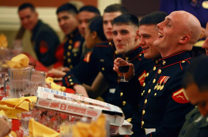 A Marine with Combat Logistics Battalion 24, 2nd Marine Logistics Group recoils in laughter after a pizza is delivered to his table during the unit’s mess night aboard Camp Lejeune, N.C., Jan. 25, 2013. No outside food is allowed during Marine Corps mess nights, and the servicemembers were forced to pay a tax, which normally includes singing a song, telling a joke, or completing some other penalty issued by the president of the mess. 