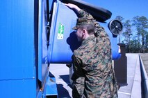 Servicemembers with 2nd Marine Logistics Group dump plastic bottles into a large recycling container aboard Camp Lejeune, N.C., Jan. 22, 2013. The unit set up the containers to help servicemembers improve recycling efforts and decrease solid waste sent to the base’s landfill. 