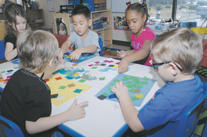 Children at Marine Corps Logistics Base Albany’s Child Development Center sharpen their motor skills during arts and crafts time Monday by creating collages using glue, paper squares and magazine cutouts.