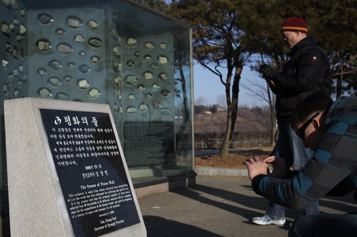 Lt. Col. F. Lance Lewis, Headquarters and Headquarters Squadron commanding officer, and Lance Cpl. Channing Leinen, H&HS crew chief, take photos of a memorial in Imjingak, a famous tourist attraction in Korea, which was developed after the North-South Joint Statement in 1972. Imjingak is also home to many other significant memorials, such as the Bridge of Freedom, which was used to free 12,773 prisoners in 1973, the Bell of Peace, which represents peace for humankind and unification for Korea in the new millennium by displaying a 21 ton bell, preceded by 21 stairs, and multiple other locales.