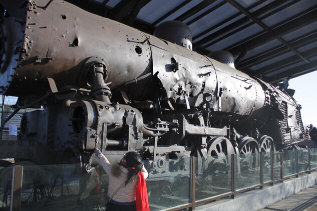 A child touches the Jangdan Station Steam Locomotive, which sits in Imnjingak, a famous tourist attraction in Korea, which was developed after the North-South Joint Statement in 1972. The locomotive is a symbol
of the division between Korea, having been left in the Korean Demilitarized Zone since it was destroyed by bombs during the Korean War.