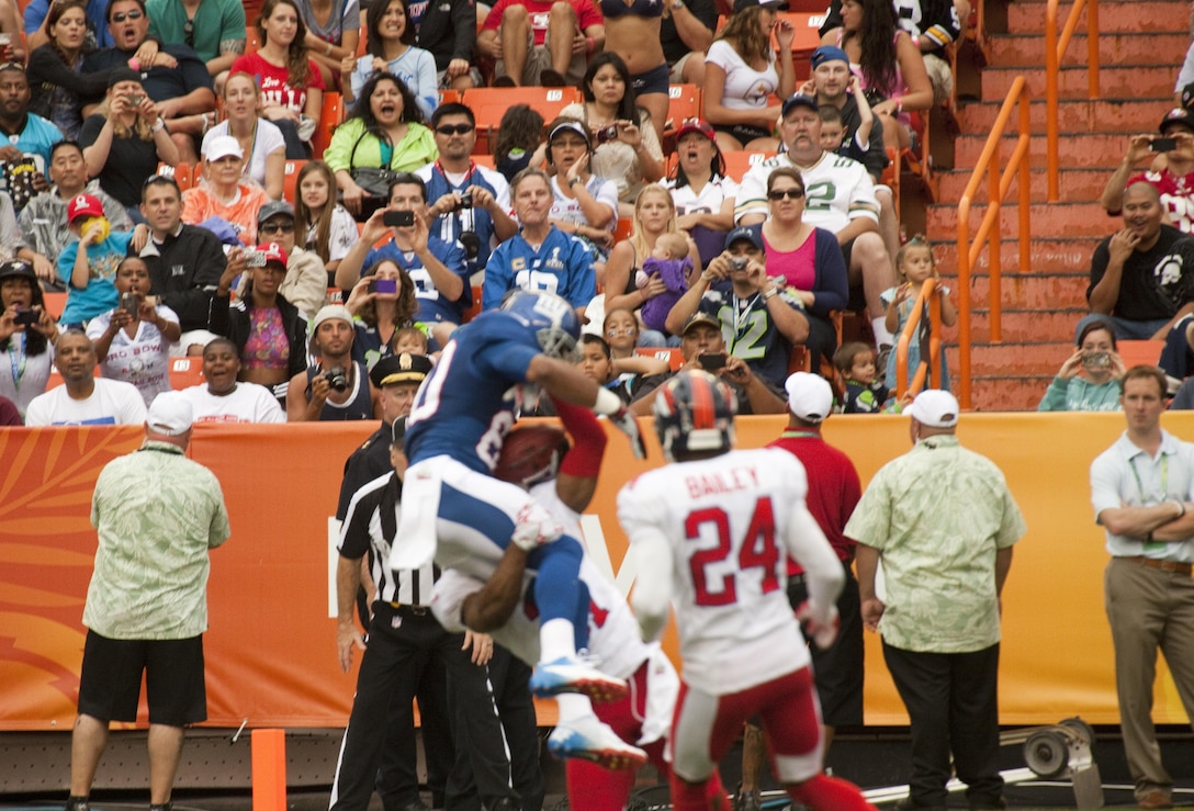 Fans watch in awe as New York Giants wide receiver Victor Cruz pulls down an improbable catch over defenders during the 2013 NFL Pro Bowl at Aloha Stadium, Jan. 27. The Marines at the Pro Bowl contributed to the festivities with a color guard, stage assistance, a troop formation and a welcoming home for Marines recently returned from deployment at halftime. 