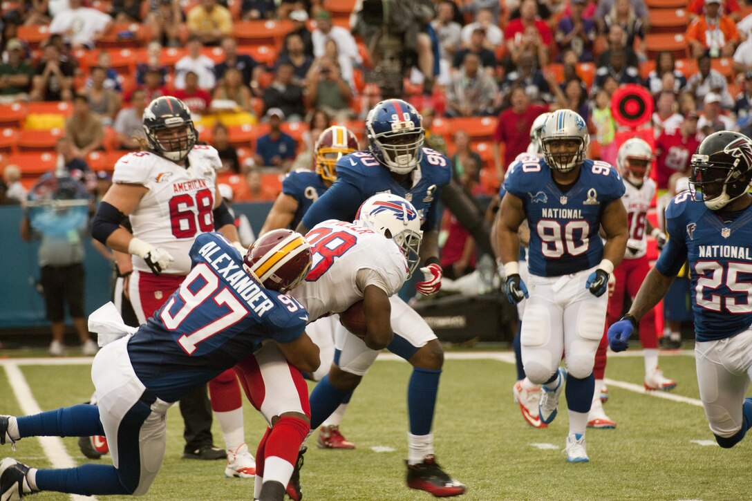 Washington Redskins linebacker Lorenzo Alexander pulls Buffalo Bills running back C.J. Spiller down to the turf during the 2013 NFL Pro Bowl, Jan. 27. The Marines at the Pro Bowl contributed to the festivities with a color guard, stage assistance, a troop formation and a welcoming home for Marines recently returned from deployment at halftime.