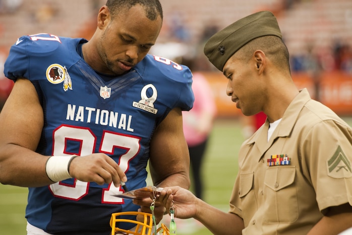 Washington Redskins linebacker Lorenzo Alexander signs an autograph for Cpl. Charles Vallero, a military policeman with Marine Corps Base Hawaii’s Provost Marshal’s Office, after the 2013 NFL Pro Bowl at Aloha Stadium, Jan. 27. Alexander signed many autographs and posed for pictures with the troops after the game, and he even gave out his email to the troops so they could drop him a line. 