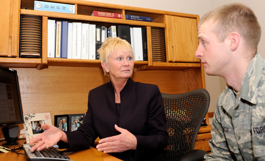 Dawn Hemming-Rich, 28th Force Support Squadron Education Office education and training section chief, explains the process for transferring Post 9/11 GI Bill benefits to family members to Staff Sgt. Keith Smith, 28th FSS resource advisor, in the base Education Office at Ellsworth Air Force Base, S.D., Jan. 24, 2013. Airmen are encouraged to visit www.gibill.va.gov for questions about the Post 9/11 and Montgomery GI Bills, but the Education Office staff is available for additional guidance. (U.S. Air Force photo by Airman Ashley J. Thum/Released) 