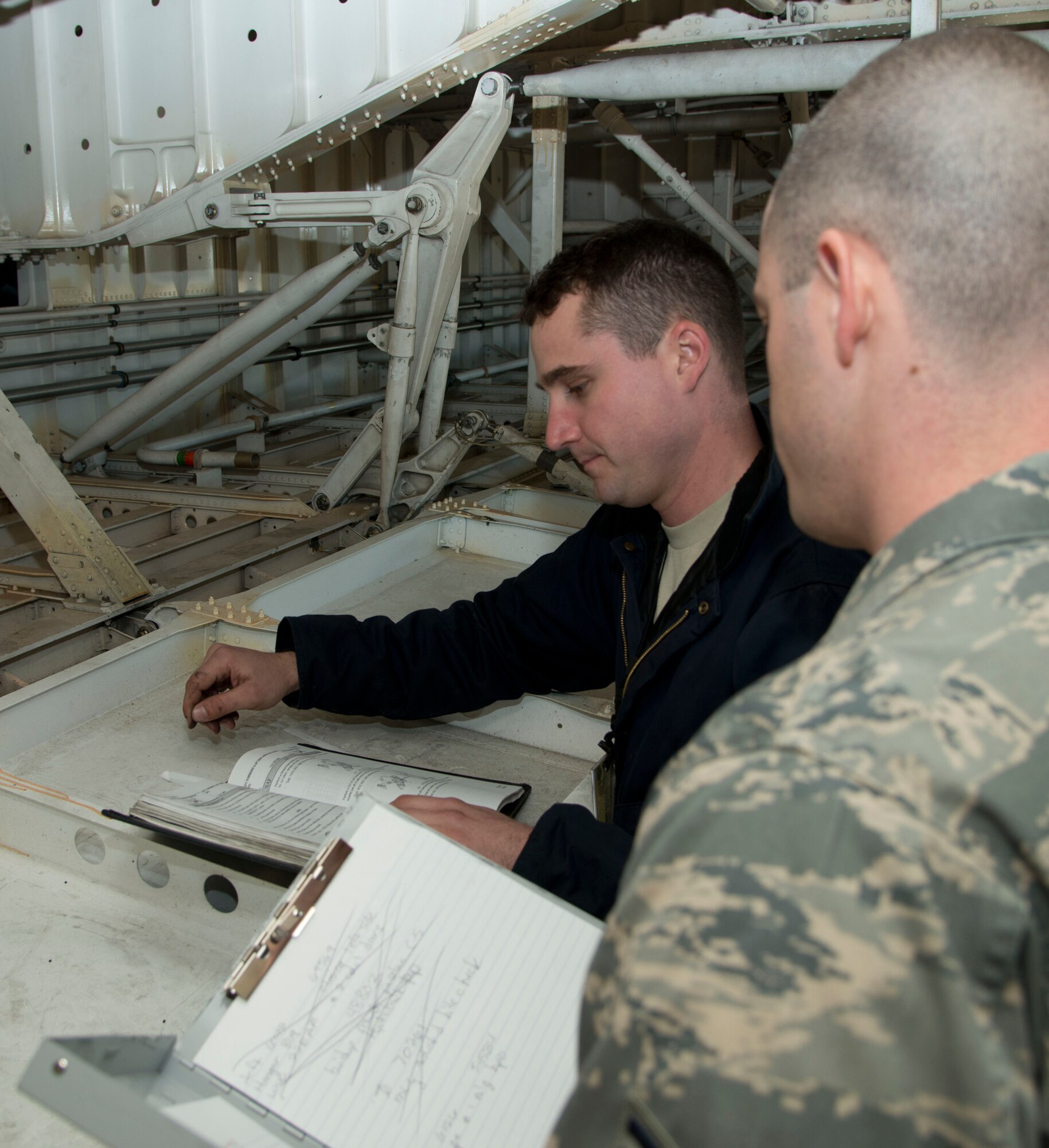 Tech. Sgt. Brandon St. Peter, 60th Maintenance Group Quality Assurance inspector, inspects Senior Airman Mark McGovern, 60th Aircraft Maintenance Squadron crew chief, on a gear inspection of a C-5 Galaxy  at Travis Air Force Base, Jan. 30, 2013. McGovern references the technical order  to talk St. Peter through the process  to ensure every task is completed and no step skipped. The QA team has increased the number of inspections performed on maintainers to help them feel more comfortable with the inspection process. (U.S. Air Force photo/Airman 1st Class Nicole Leidholm)