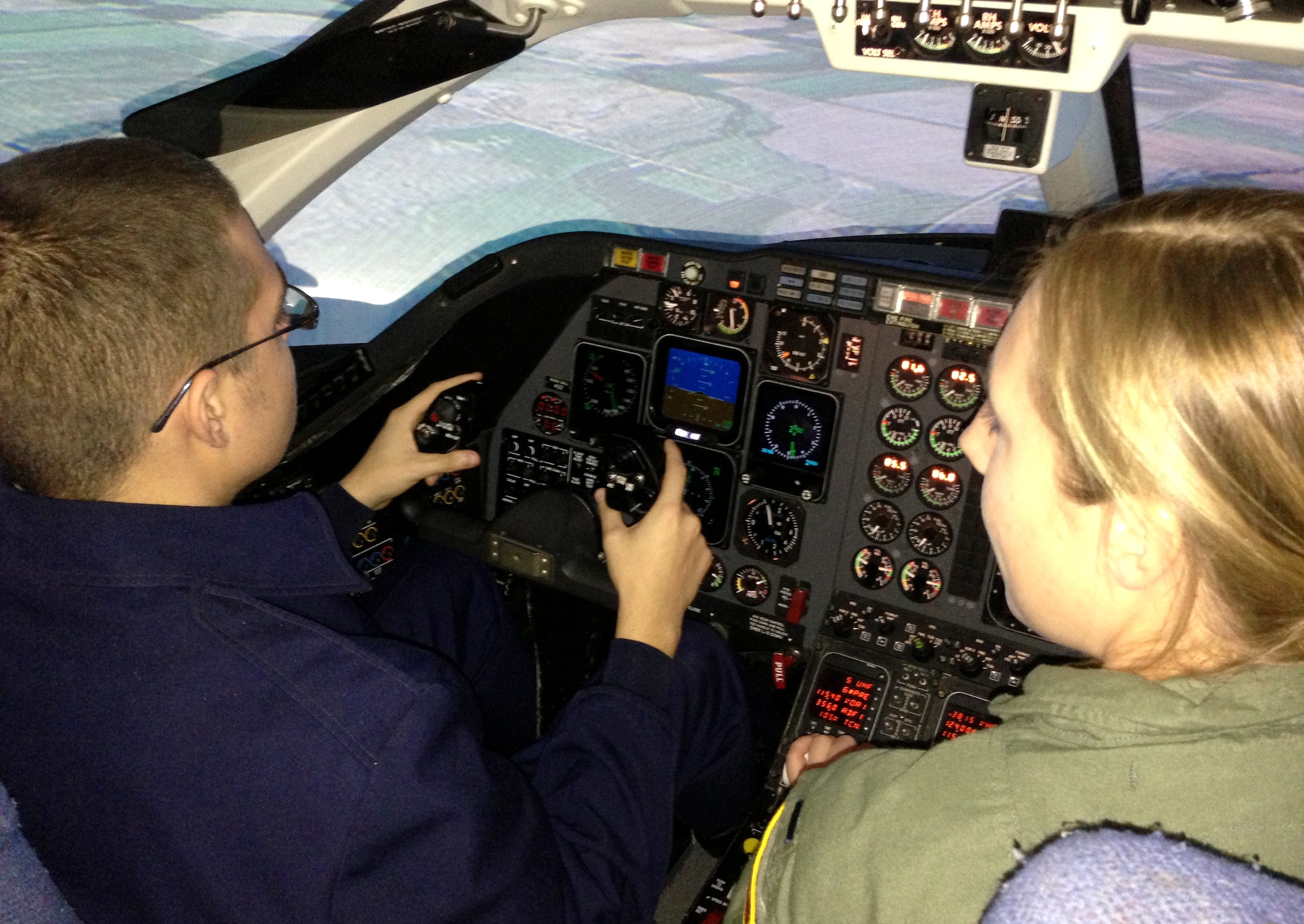 Air Force Junior ROTC Cadet David Yargee, left, gets a hands-on tour of a T-1 flight simulator from 1st Lt Michelle Bosch with the 3rd Flying Training Squadron at Vance Air Force Base, Okla. (U.S. Air Force photo/ Linda Frost)