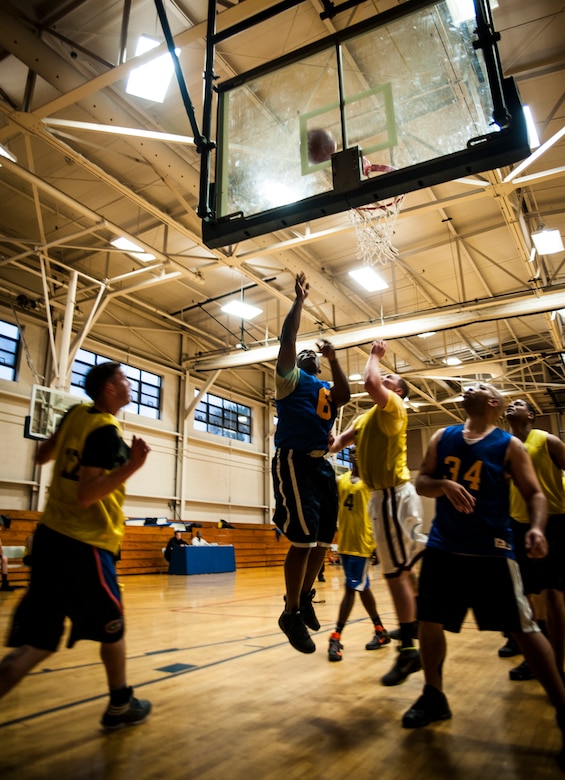 A 628th Comptroller Squadron player shoots from underneath the hoop while members of the 628th Logistics Readiness Squadron team try and block the shot during a game against the 628th LRS Jan. 29, 2013, at Joint Base Charleston, S.C. The 628th LRS beat the 628th CPTS 52 to 46. Games are scheduled to be played on Tuesday, Wednesdays and Thursdays at 5:30, 6:30 and 7:30 p.m. at the Fitness Center at the JB Charleston - Air Base. (U.S. Air Force photo/ Senior Airman Dennis Sloan)