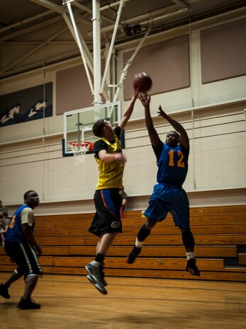 Xavier Miles, 628th Comptroller Squadron, fires off  a shot while Aaron Megger, 628th Logistics Readiness Squadron, jumps up to block the ball during an intramural basketball game Jan. 29, 2013, at Joint Base Charleston, S.C. The 628th LRS beat the 628th CPTS 52 to 46. Games are scheduled to be played on Tuesday, Wednesdays and Thursdays at 5:30, 6:30 and 7:30 p.m. at the Fitness Center at the JB Charleston - Air Base. (U.S. Air Force photo/ Senior Airman Dennis Sloan)