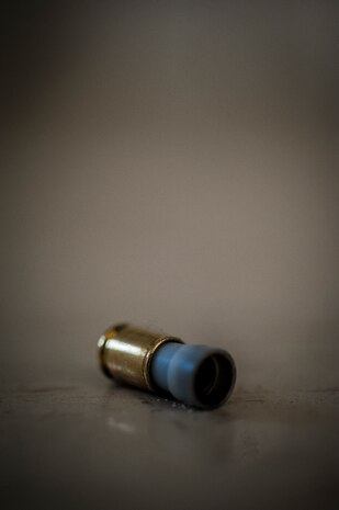 An M-9 pistol Simunition round casing lies on the ground after a 628th Security Forces Squadron Airman fired the round during a close quarters battle exercise Jan. 28, 2013, at Joint Base Charleston – Air Base, S.C. The unit requires all of its members to perform the CQB training twice a year. (U.S. Air Force photo/Senior Airman Dennis Sloan)