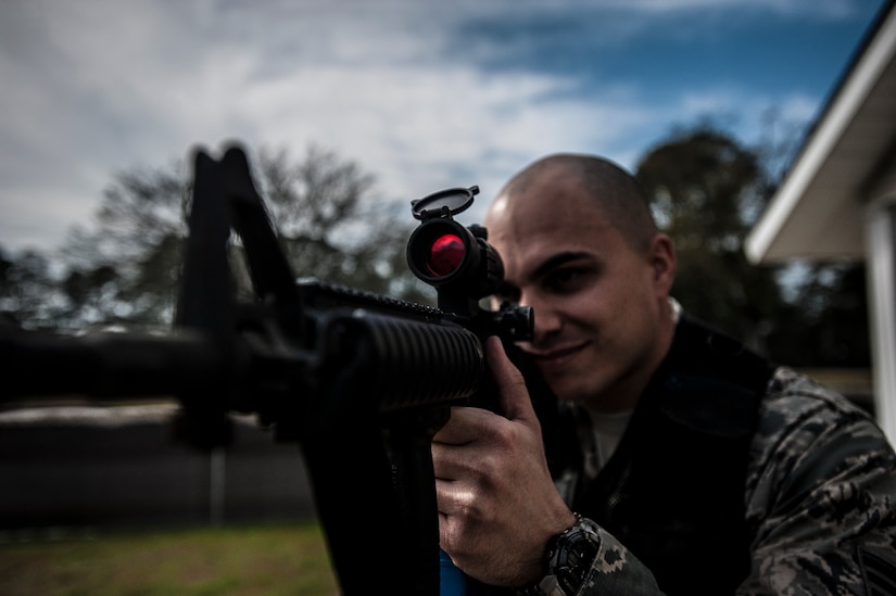 Staff Sgt. Vincent Bustillo, 628th Security Forces Squadron patrolman, looks through the scope mounted on his M4 carbine before performing close quarters battle training Jan. 28, 2013, at Joint Base Charleston – Air Base, S.C. The unit requires all of its members to perform the CQB training twice a year. (U.S. Air Force photo/Senior Airman Dennis Sloan)