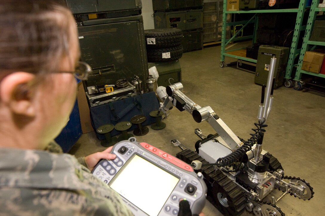Senior Airman Danee Hicks, 28th Civil Engineer Squadron explosive ordnance disposal journeyman, controls an HD-1 Air Force Medium Size Robot via a large remote control panel at Ellsworth Air Force Base, S.D., Dec. 20, 2012. An HD-1 AFMSR can travel wirelessly, lift up to 30 pounds and elevate up to four and a half feet, ultimately keeping operators safe during potentially dangerous explosive investigations. (U.S. Air Force photo by Airman 1st Class Audra M. Hornbacher/Released)