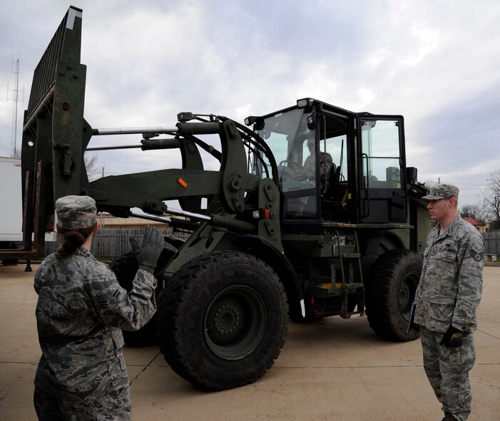 Airman 1st Class Jaquelyn Mungavin, 2nd Logistics Readiness Squadron vehicle operations, directs Airman 1st Class Karl Klein, 2 LRS vehicle operations, as Staff Sgt. William Winters, 2 LRS, supervises, on Barksdale Air Force Base, La., Jan. 30. Mungavin and Klein have recently arrived from technical school and are qualifying on the use and operations of a 10k all-terrain fork lift which is one of many vehicles new Airmen learn to use. (U.S. Air Force photo/Airman 1st Class Andrew Moua)
