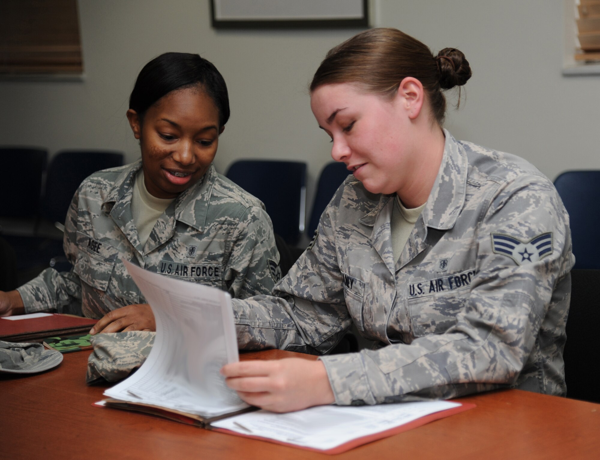 Staff Sgt. Kimberly Agee and Senior Airman Allison Meaney, 81st Surgical Operations Squadron, review their mobility folders after processing through the deployment line during a humanitarian deployment exercise, Jan. 30, 2013, at the Taylor Logistics Center, Keesler Air Force Base, Miss.  The exercise scenario consists of an earthquake in Arkansas with a warning order for a deployment to Little Rock, Ark.  (U.S. Air Force photo by Kemberly Groue)