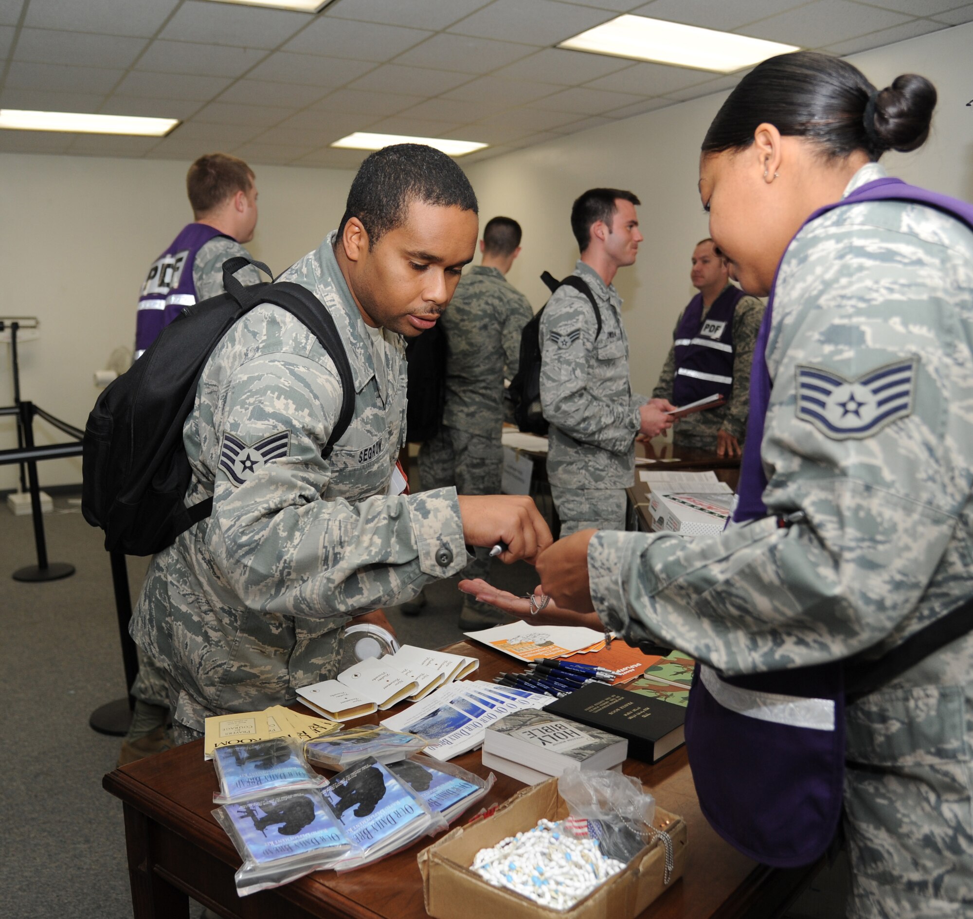 Staff Sgt. Shaun Sergow, 81st Security Forces Squadron, receives dog tags from Staff Sgt. Tomeka Gordon, 81st Training Wing, at the chaplain’s table at the the deployment eligibility line during a humanitarian deployment exercise, Jan. 30, 2013, at the Taylor Logistics Center, Keesler Air Force Base, Miss.  The exercise scenario consists of an earthquake in Arkansas with a warning order for a deployment to Little Rock, Ark.  (U.S. Air Force photo by Kemberly Groue)